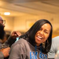 Two event guests sitting at table and laughing at something off camera